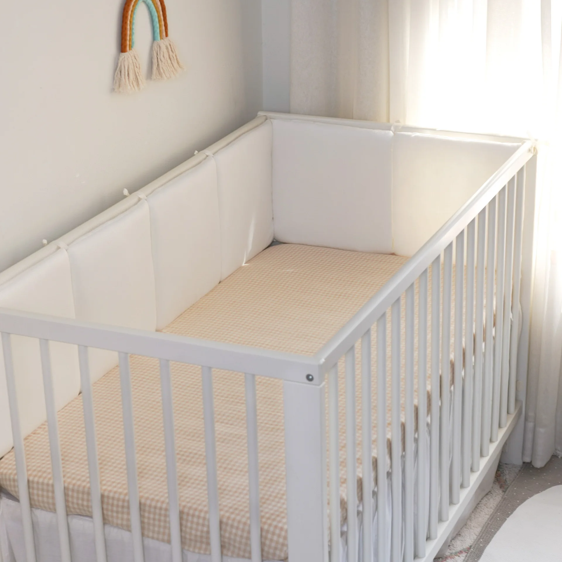 Lit bébé à barreaux design minimaliste en bois rembourré coussins côtés sécurité style moderne neutre chambre 